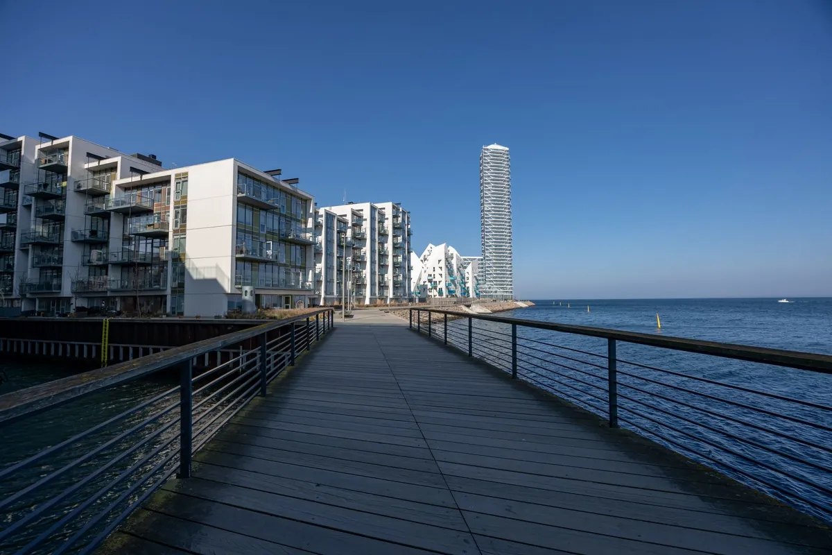 Boligbyggeri og træbro langs vandet på Aarhus Ø